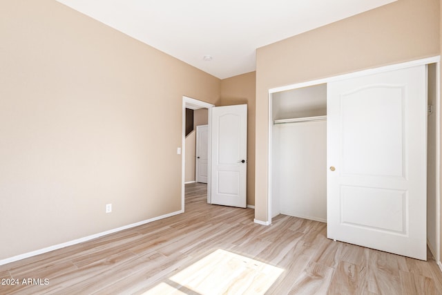 unfurnished bedroom featuring light hardwood / wood-style flooring and a closet