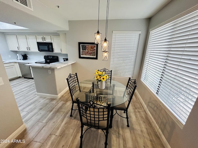 dining space with a wealth of natural light and light hardwood / wood-style flooring