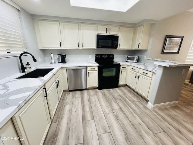 kitchen featuring light wood-type flooring, kitchen peninsula, sink, and black appliances