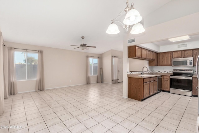 kitchen with ceiling fan with notable chandelier, appliances with stainless steel finishes, sink, hanging light fixtures, and light tile patterned floors