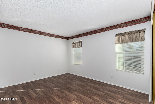 unfurnished room featuring plenty of natural light, a textured ceiling, and dark hardwood / wood-style flooring