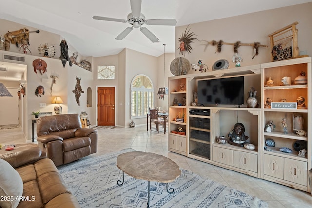 living area featuring arched walkways, visible vents, a ceiling fan, tile patterned floors, and vaulted ceiling