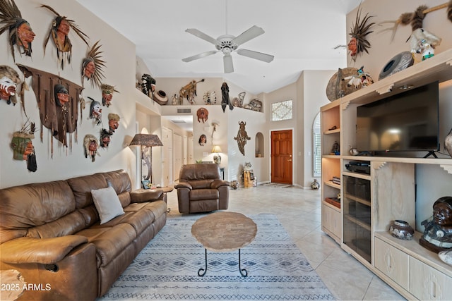 living room with arched walkways, high vaulted ceiling, light tile patterned flooring, and a ceiling fan