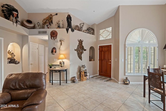 foyer with baseboards, visible vents, arched walkways, high vaulted ceiling, and light tile patterned flooring