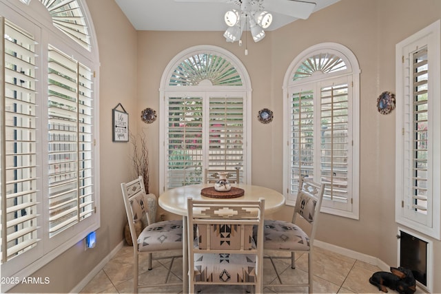 dining space with ceiling fan, baseboards, and light tile patterned floors