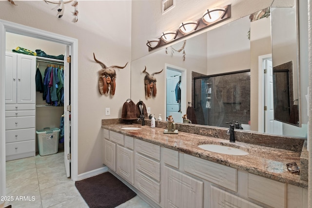 bathroom featuring double vanity, a sink, visible vents, and a shower stall