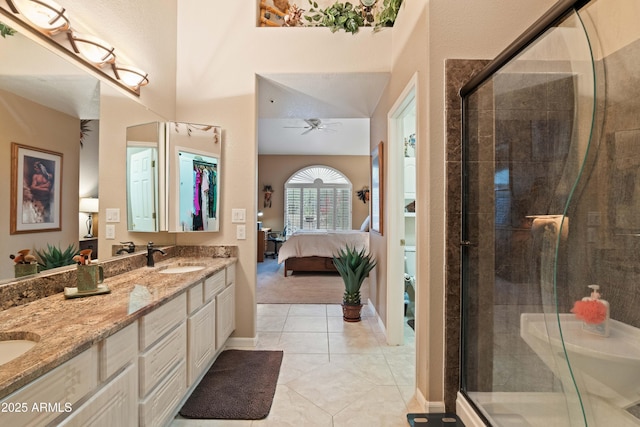 full bathroom featuring double vanity, a stall shower, connected bathroom, a sink, and tile patterned flooring