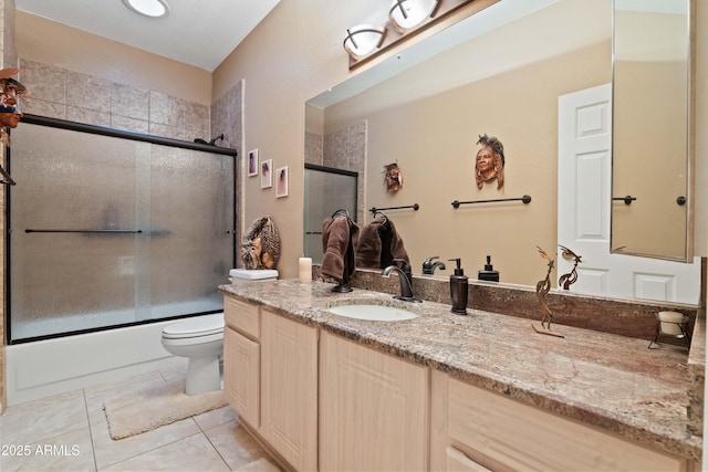 bathroom featuring enclosed tub / shower combo, vanity, toilet, and tile patterned floors