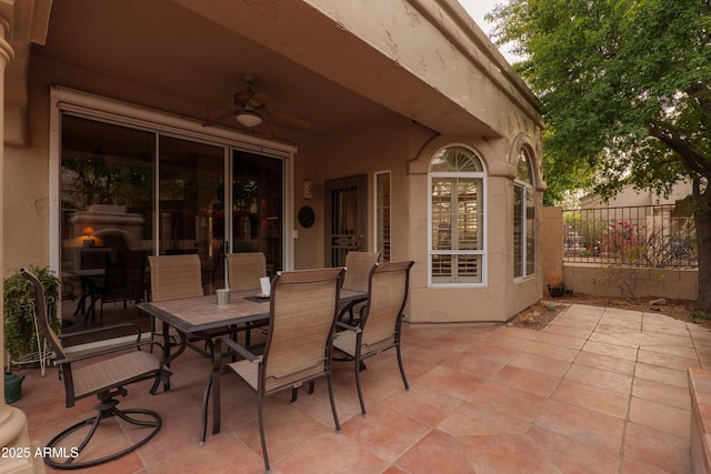 view of patio / terrace with fence, outdoor dining area, a ceiling fan, and french doors