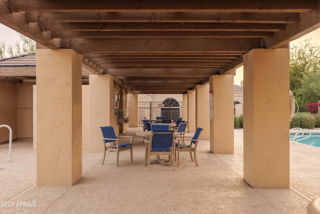 view of patio with outdoor dining space, an outdoor pool, and fence