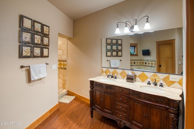 full bath with tasteful backsplash, double vanity, a sink, and wood finished floors