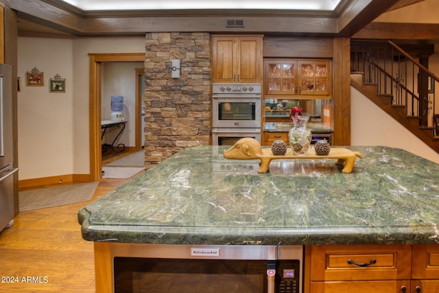 kitchen with visible vents, baseboards, glass insert cabinets, brown cabinets, and double oven