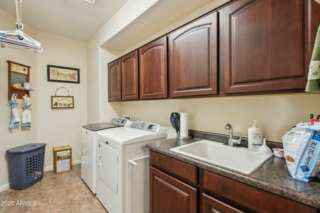 clothes washing area featuring sink, light tile patterned floors, cabinets, and washing machine and clothes dryer