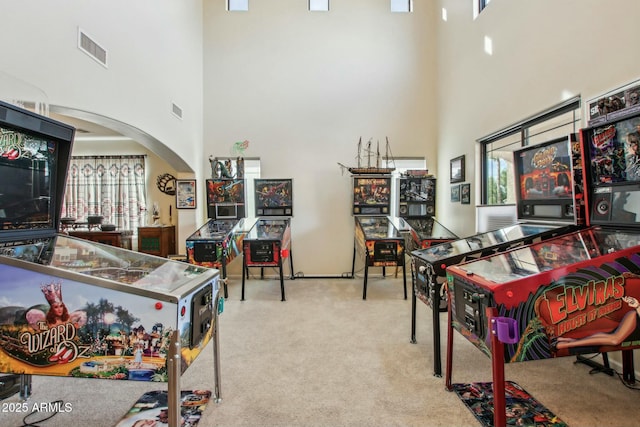 rec room with light carpet and a high ceiling