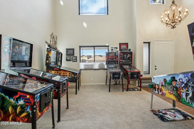 recreation room with an inviting chandelier, a high ceiling, and carpet flooring