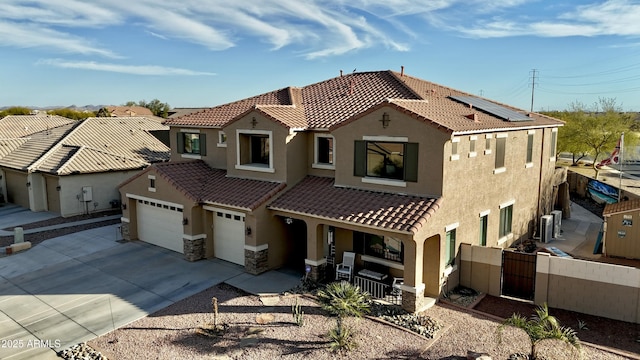 mediterranean / spanish home featuring a garage, solar panels, and a porch