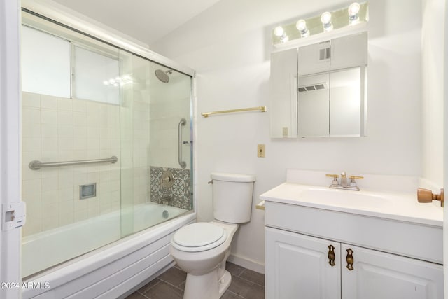 full bathroom featuring vanity, toilet, combined bath / shower with glass door, and tile patterned flooring