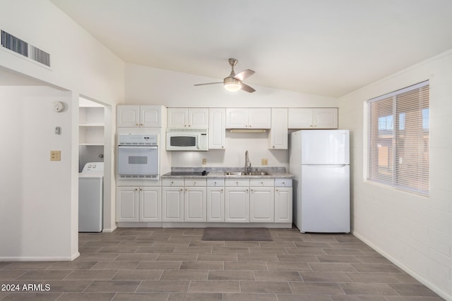 kitchen featuring washer / dryer, sink, vaulted ceiling, and white appliances