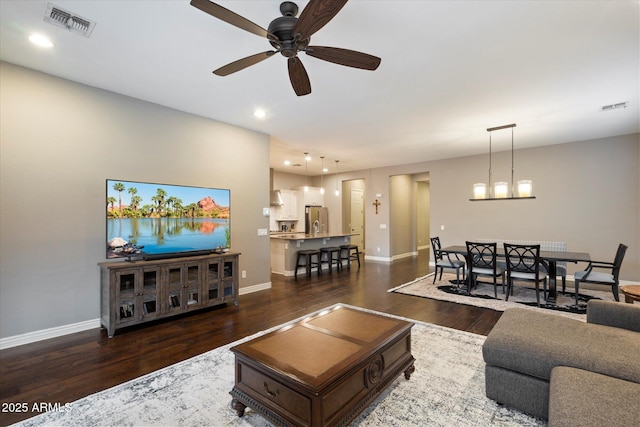 living area featuring visible vents, baseboards, and dark wood finished floors