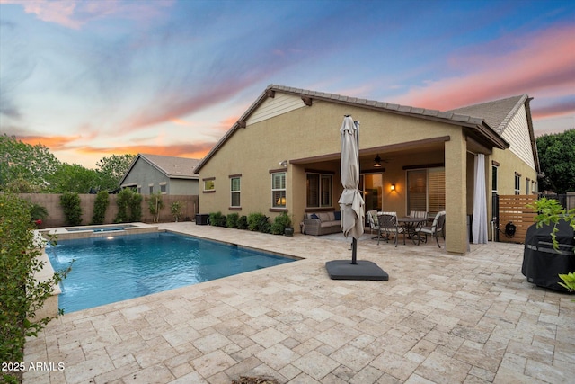 view of swimming pool featuring a pool with connected hot tub, a fenced backyard, outdoor dining space, and a patio area