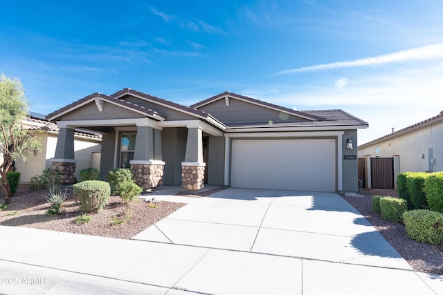 craftsman house with a tiled roof, concrete driveway, stucco siding, a garage, and stone siding