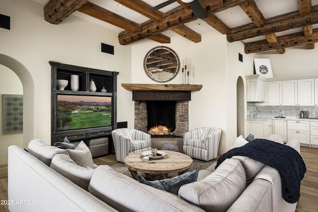 living room featuring beam ceiling, a fireplace, and dark hardwood / wood-style floors