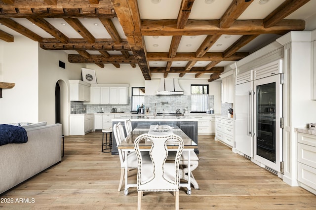 kitchen with backsplash, white cabinets, and light wood-type flooring