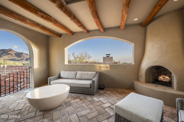 view of patio with an outdoor fireplace and a mountain view