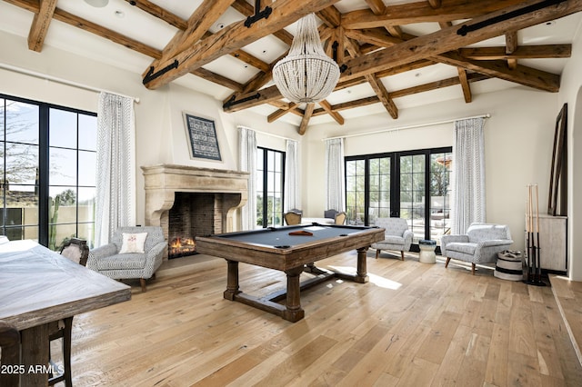 recreation room featuring billiards, a chandelier, a high ceiling, light hardwood / wood-style floors, and beam ceiling