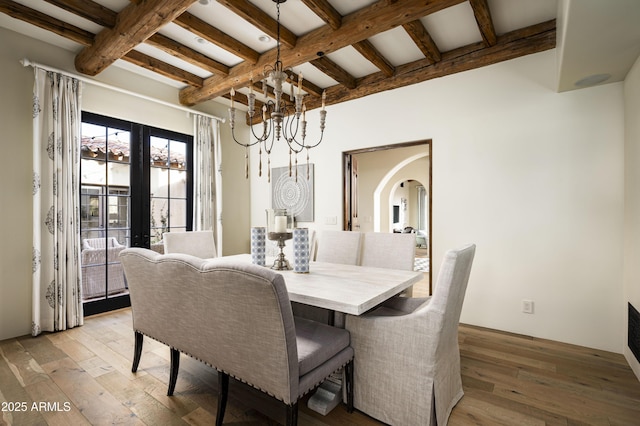 dining area featuring french doors, beam ceiling, light hardwood / wood-style floors, and a notable chandelier