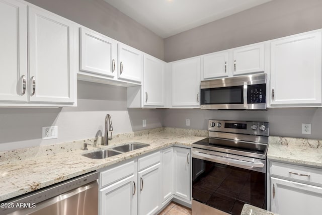 kitchen with appliances with stainless steel finishes, sink, and white cabinets