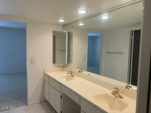 full bath with double vanity, a sink, and tile patterned floors