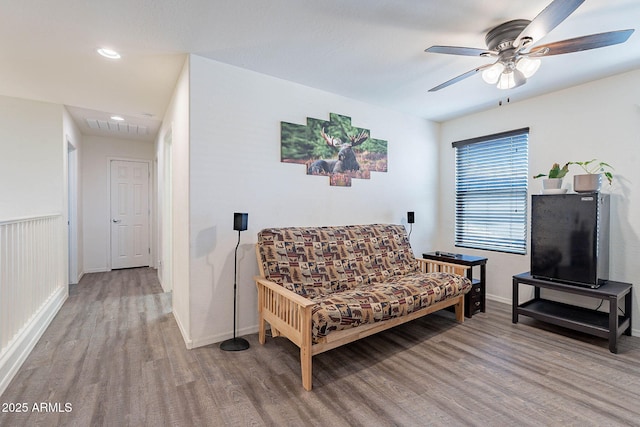 sitting room featuring wood finished floors, ceiling fan, baseboards, and recessed lighting
