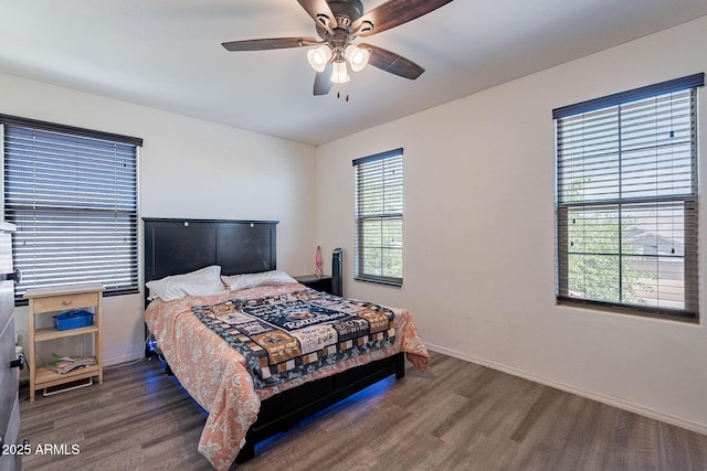 bedroom with wood finished floors, multiple windows, and baseboards