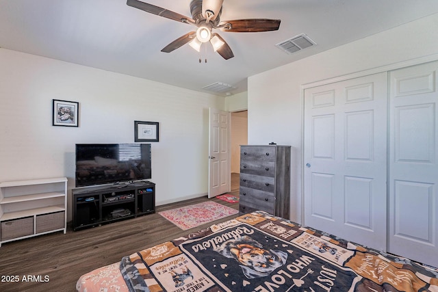 bedroom with dark wood-style flooring, a closet, a ceiling fan, and baseboards
