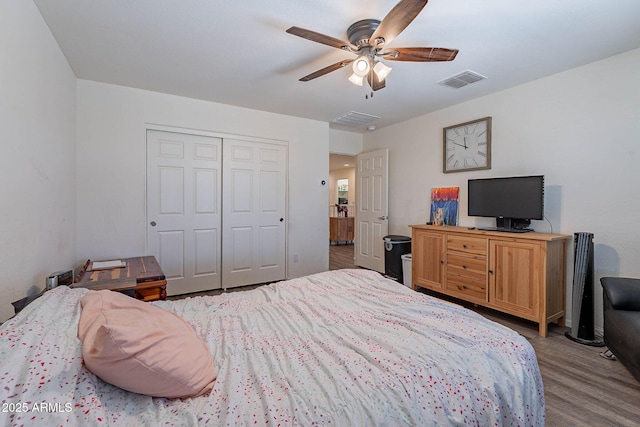 bedroom with a closet, wood finished floors, and a ceiling fan