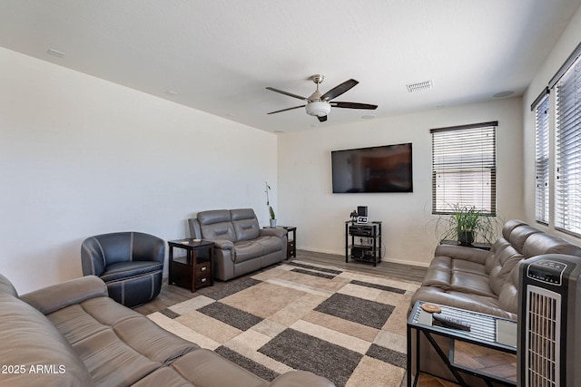 living area featuring ceiling fan, light wood-style floors, and baseboards