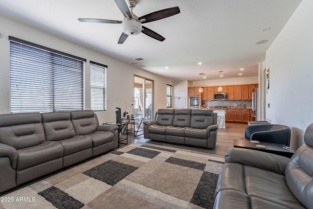 living room with a ceiling fan and recessed lighting