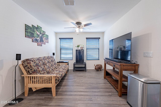 living room featuring a ceiling fan, wood finished floors, and baseboards