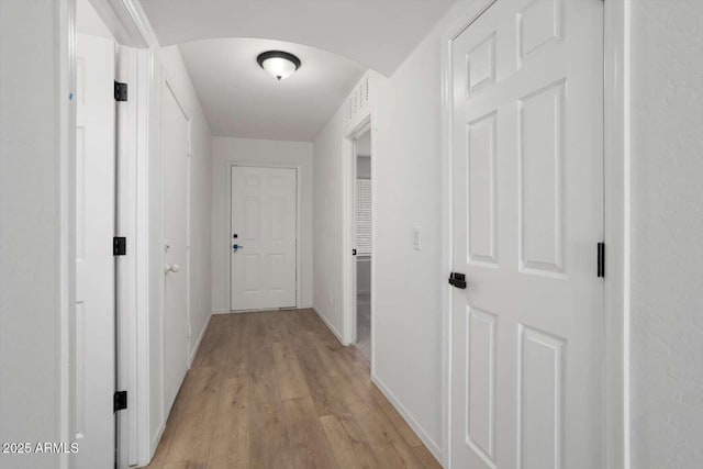 23772 W Grove St, Buckeye, AZ 85326 - hall featuring light wood-style floors, arched walkways, and baseboards