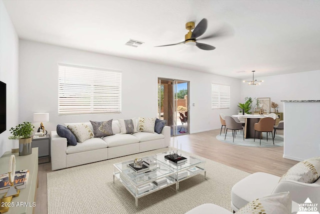 23772 W Grove St, Buckeye, AZ 85326 - living room featuring light wood finished floors, ceiling fan, and a chandelier