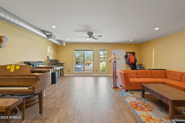 living room with ceiling fan and light hardwood / wood-style flooring