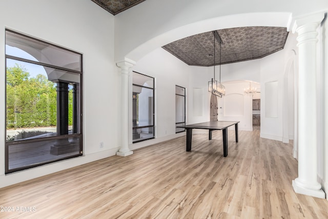 interior space with a towering ceiling, a chandelier, and light wood-type flooring