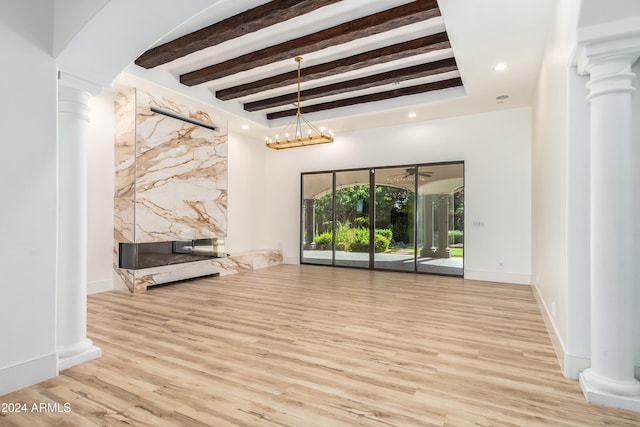 unfurnished living room featuring beamed ceiling, decorative columns, a notable chandelier, and light wood-type flooring