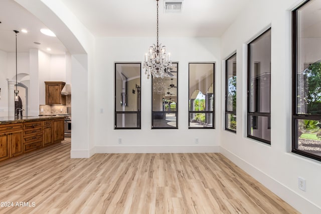 dining area with a notable chandelier and light hardwood / wood-style flooring