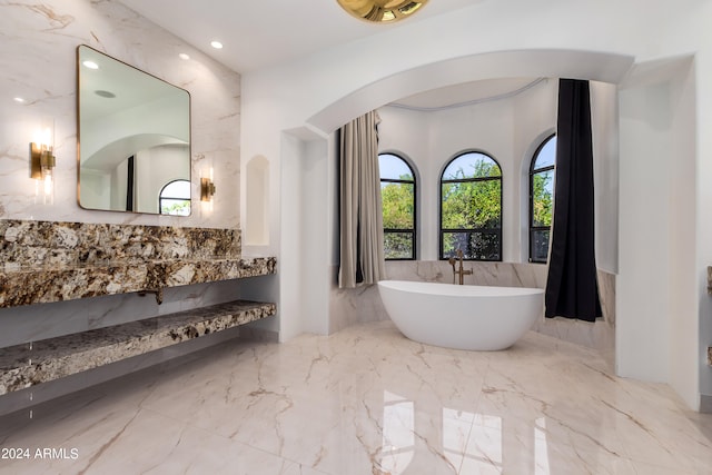 bathroom featuring vanity, tile walls, and a bath