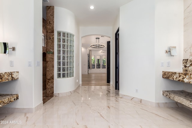 corridor featuring an inviting chandelier