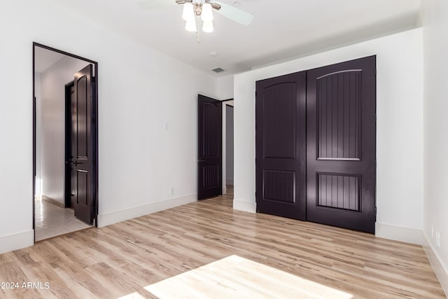 unfurnished bedroom with light hardwood / wood-style floors, a closet, and ceiling fan