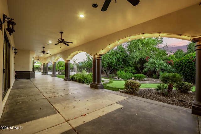 patio terrace at dusk featuring ceiling fan