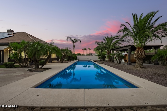 pool at dusk with a patio